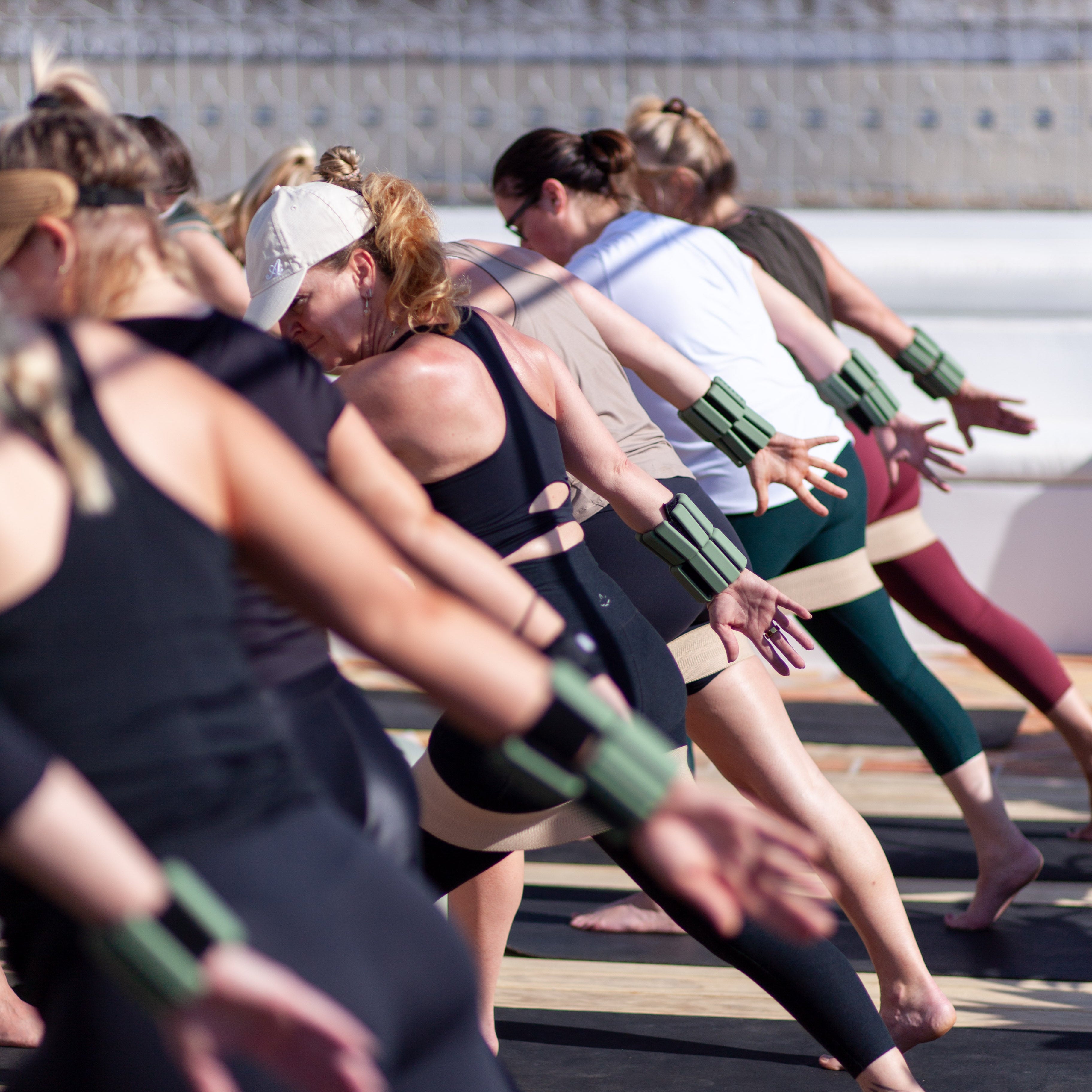 Group of people participating in a yoga or exercise class outdoors.