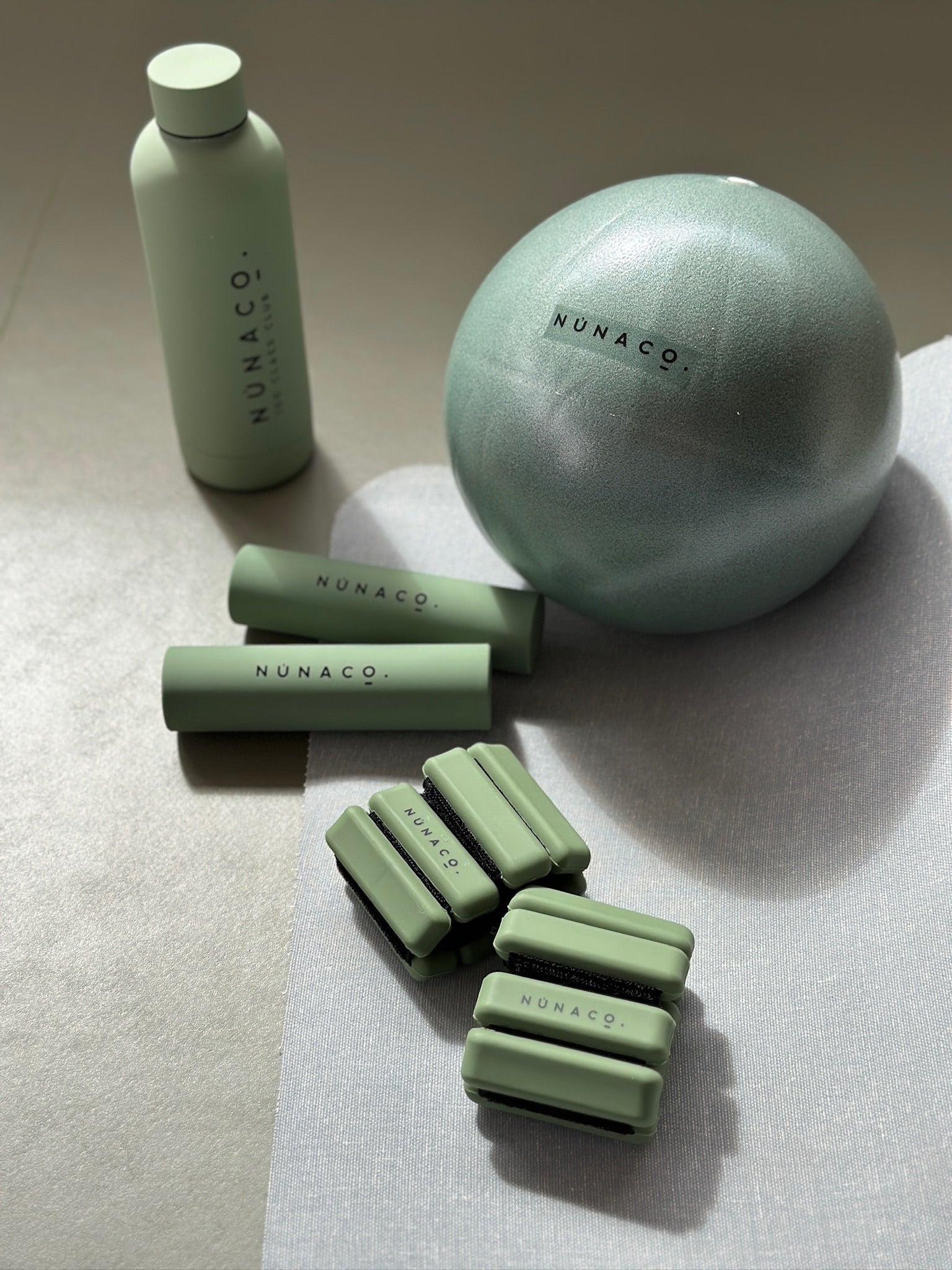 Collection of green skincare products with 'Nunaco' branding on a neutral background