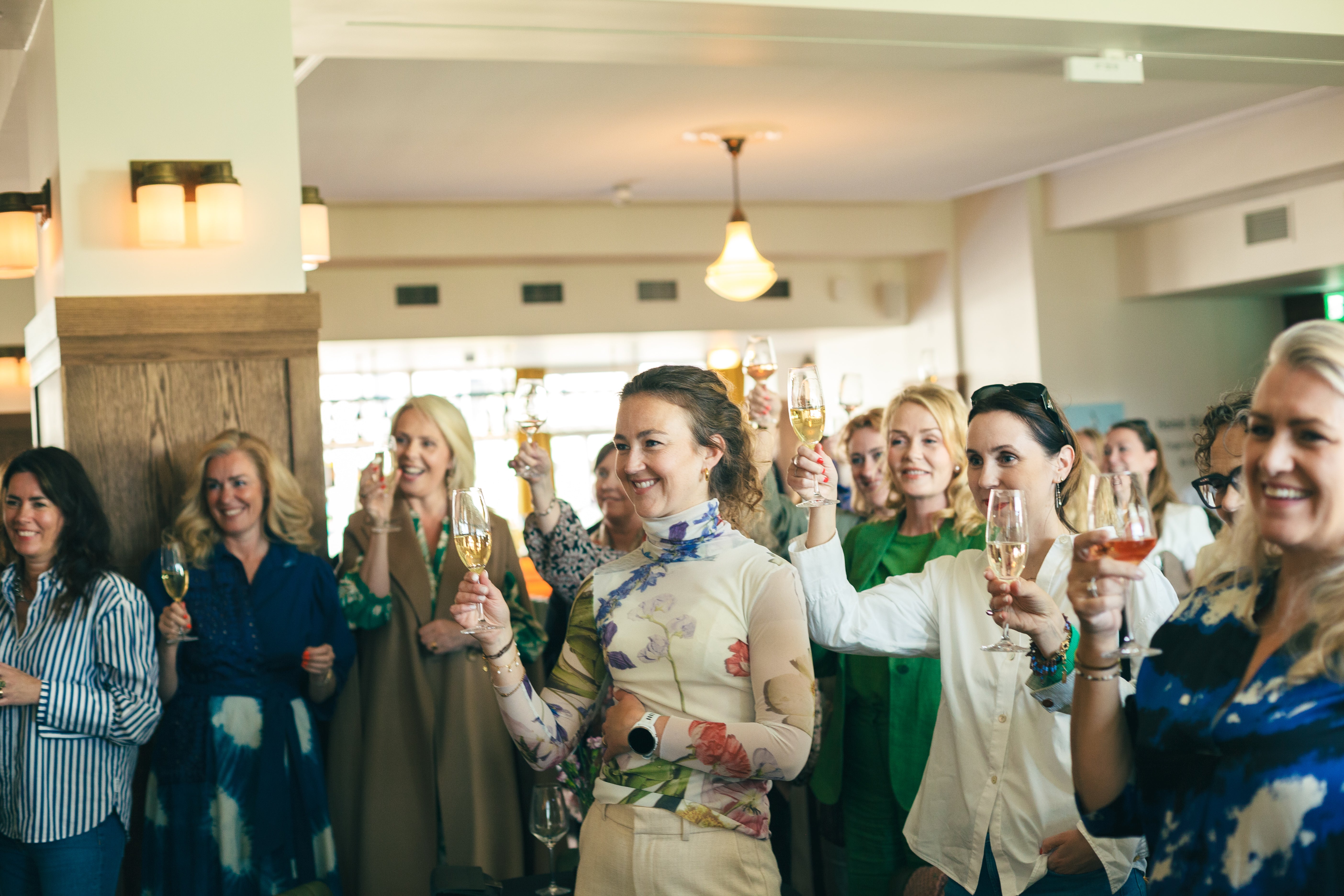 Group of women raising glasses in a celebratory setting
